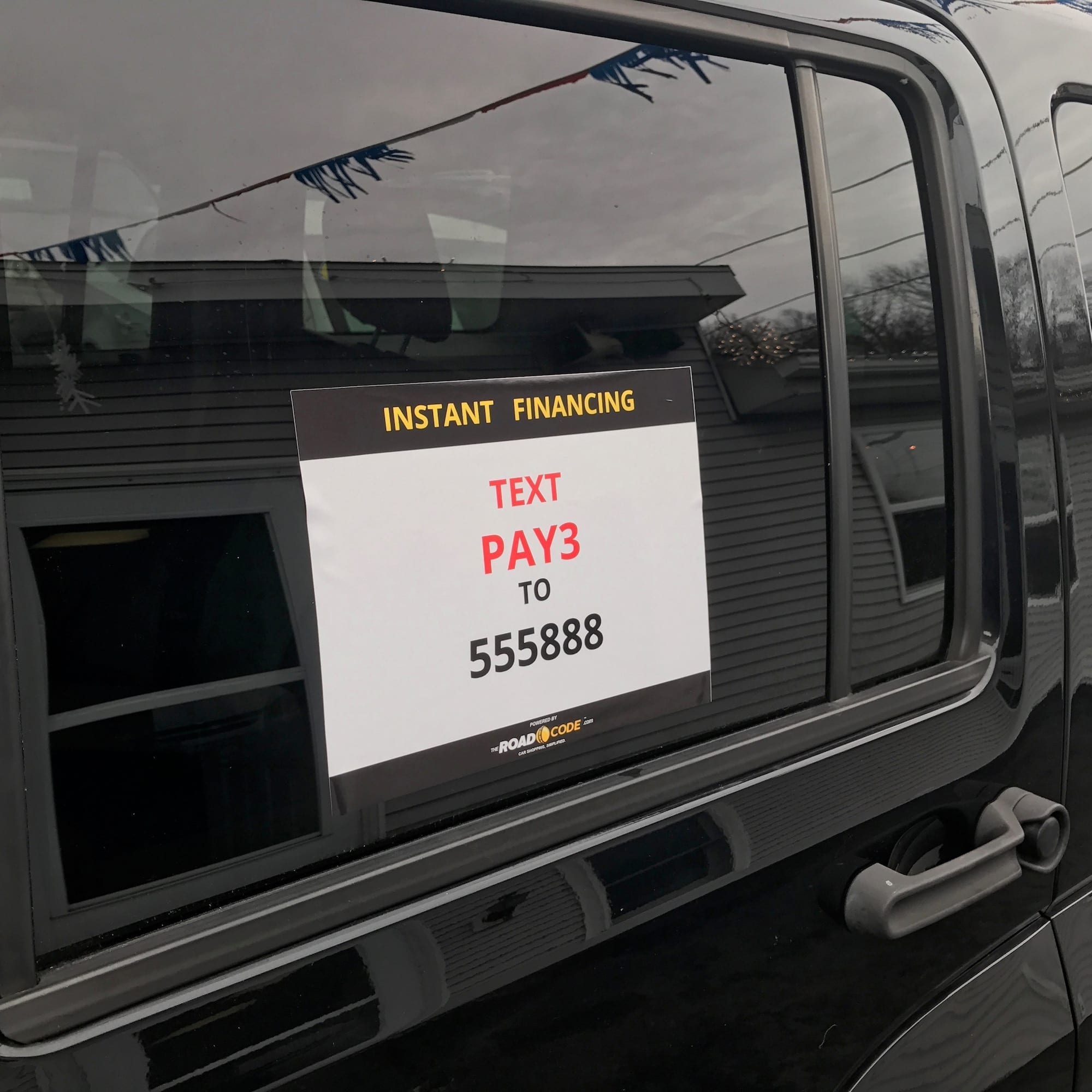 Sign in window of black vehicle, Instant Financing, Text PAY3 to 555888