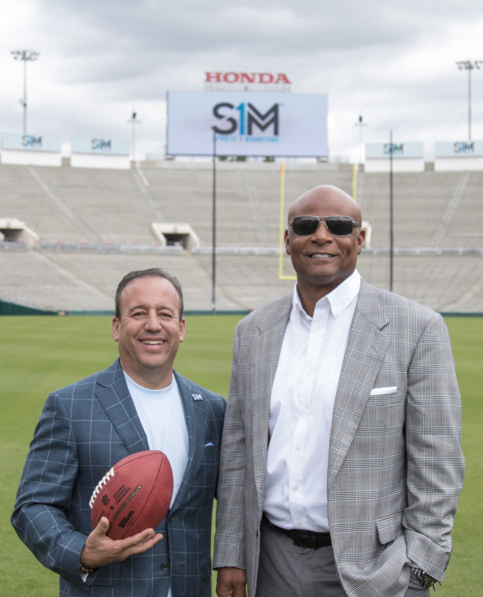 Two men in suits standing on a football field