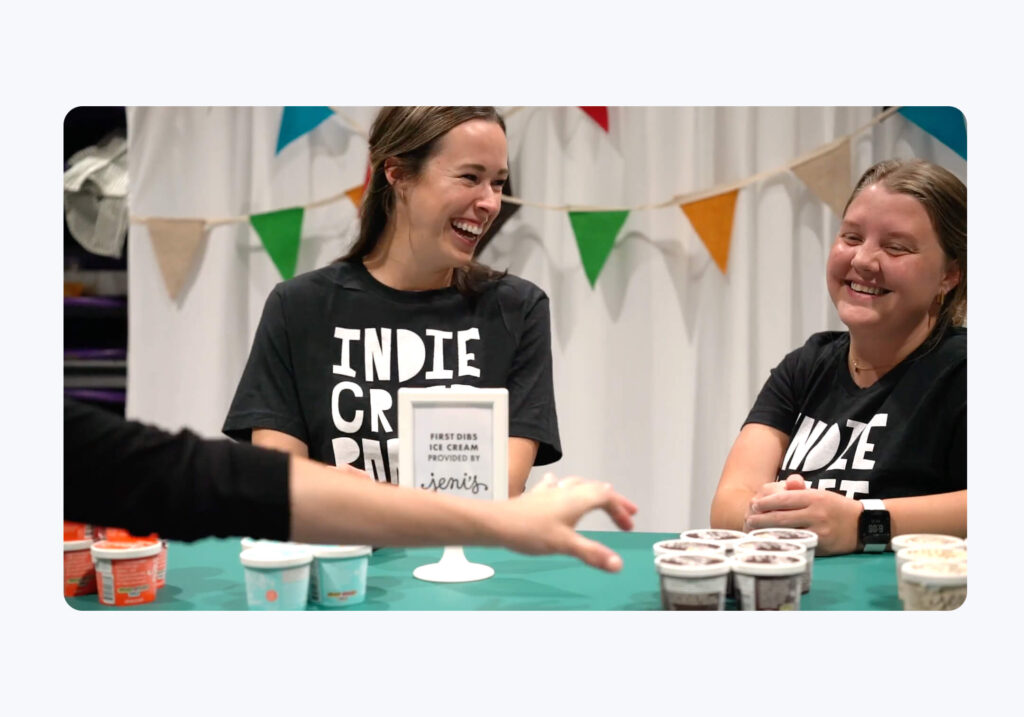 Two smiling event attendees at a craft fair who are wearing shirts that say "Indie Craft Parade"